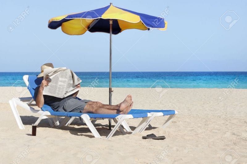20018045-Lazy-relaxing-newspaper-reading-man-at-beach-Stock-Photo-umbrella