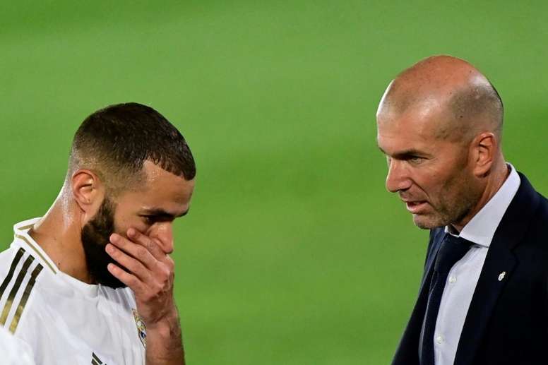 Benzema y Zidane hablan durante un partido.